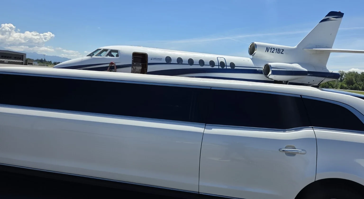 White stretch limousine beside a private jet on the tarmac at Skagit Regional Airport in Burlington, Washington