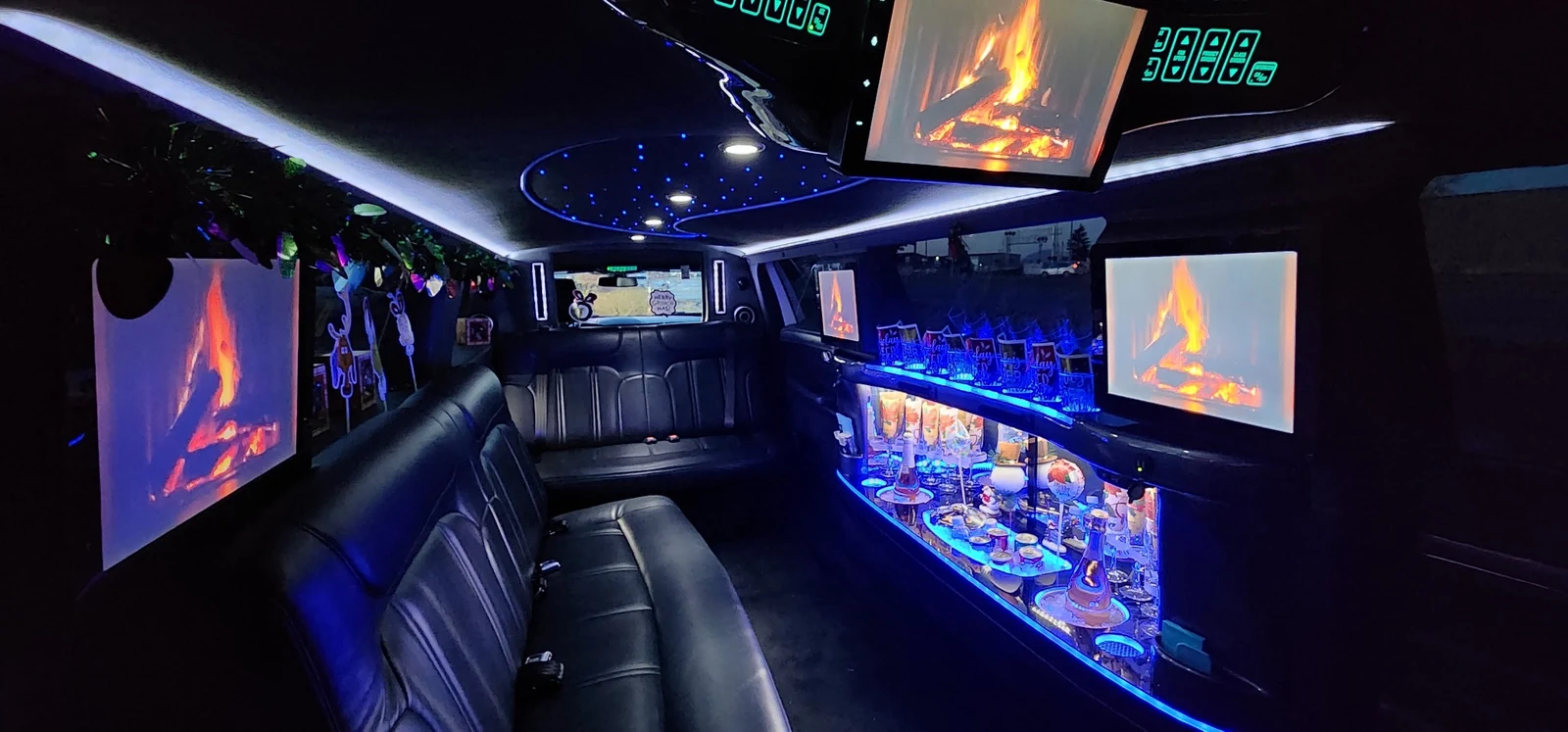 Actual interior of the Whidbey Island Limo stretch limousine with black leather seating, ambient lighting, entertainment screens and glassware